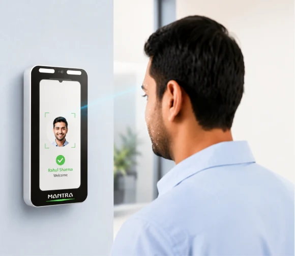 Employee marking attendance on a wall-mounted face recognition device